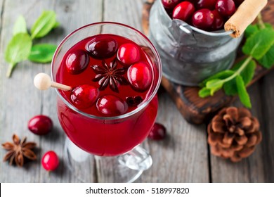 Fresh Cranberry Juice With Cinnamon And Anise In Glass Jars On The Old Wooden Background. Selective Focus.Top View.