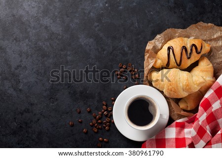 Fresh croissants and coffee on stone table. Top view with copy space