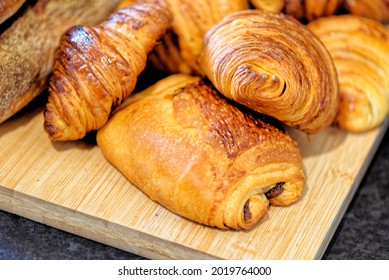 Fresh croissants and pain au chocolate, puff pastry and buttered french croissant on a plate. Food and breakfast concept. Detail of desserts and fresh pastries - Shutterstock ID 2019764000