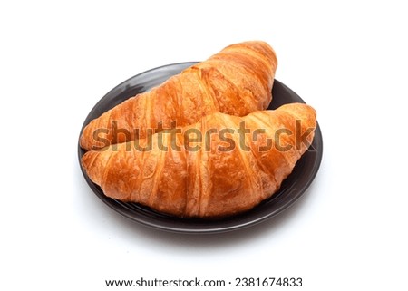 Fresh croissants in a plate on a white background close-up.
