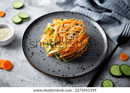 Fresh cucumber carrots salad with sesame seeds in a bowl. selective focus