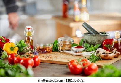 Fresh culinary herbs, spices and salad ingredients with a stone pestle and mortar on a counter in a kitchen during preparation of the dinner - Shutterstock ID 1181786572