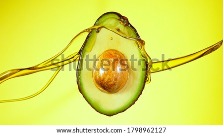 Fresh cut avocado with oil stream. Concept of healthy fruit also useful in cosmetics.