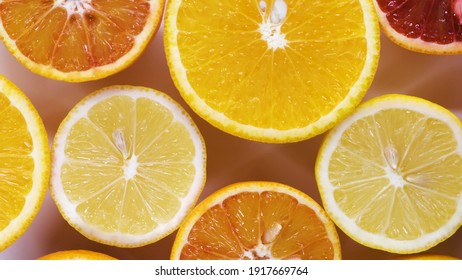 Fresh Cutted Yellow Lemons, Oranges And Red Oranges Spin On Table Top Down View. Freshly Picked Sour And Sweet Cut Citrus On Turntable Detailed View Isolated.