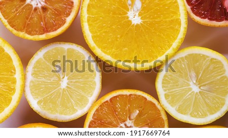 fresh cutted yellow lemons, oranges and red oranges spin on table top down view. Freshly picked sour and sweet cut citrus on turntable detailed view isolated.