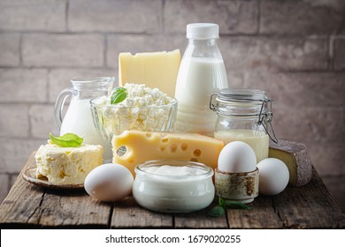 Fresh dairy products, milk, cottage cheese, eggs, yogurt, sour cream and butter on wooden table - Shutterstock ID 1679020255
