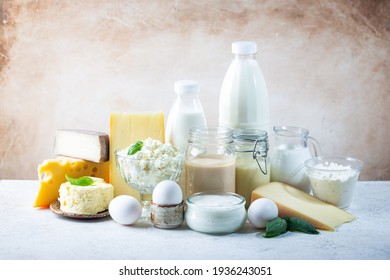Fresh dairy products, milk, cottage cheese, eggs, yogurt, sour cream and butter on white table - Shutterstock ID 1936243051
