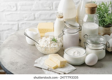 Fresh dairy products, milk, cottage cheese, eggs, yogurt, sour cream and butter on kitchen table - Powered by Shutterstock