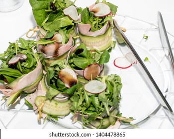 Fresh Dark Leafy Greens Salad Lettuce Mix With Cucumbers, Rucola, Radishes Dressing On A Plate During Breakfast Buffet Or Brunch Catering Event, Food Pliers On The Plate. Vegetarian And Vegan Dish