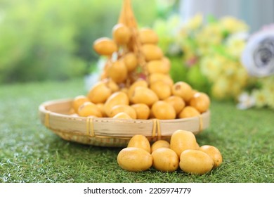 Fresh Date Plum, Yellow Sweet Desert Fruit. Date Plum Is Popular For Muslim Sweet, Laying On Green Grass.