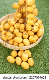 Fresh Date Plum, Yellow Sweet Desert Fruit. Date Plum Is Popular For Muslim Sweet, Laying On Green Grass.