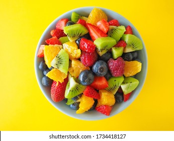 Fresh delicious fruit salad on bright yellow background - Shutterstock ID 1734418127