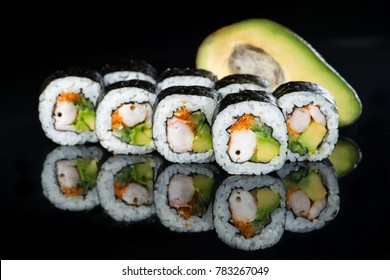 Fresh delicious Japanese sushi with avocado, cucumber, shrimp and caviar on dark background