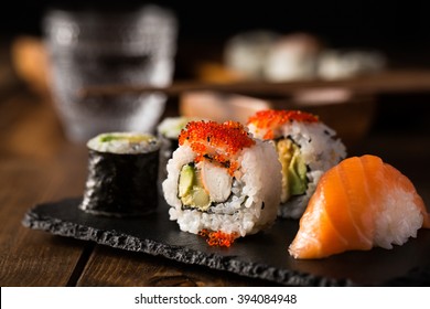 Свежие и вкусные маки и нигири суши и сакэ стакан.