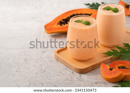 Fresh delicious papaya milk smoothie in glass cup on gray table background for tropical fruit design concept. Foto d'archivio © 
