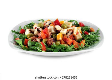 A fresh and delicious plate of crab meat, octopus, olives, peppers and rucola isolated on white