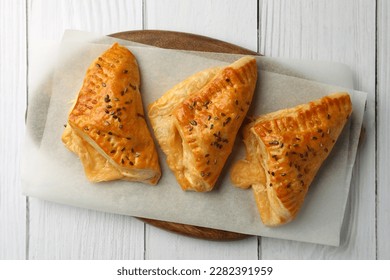 Fresh delicious puff pastry on white wooden table, top view
