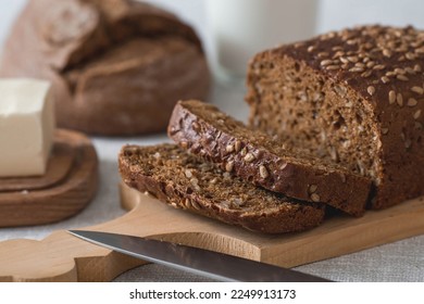 Fresh delicious whole grain rye bread with seeds close-up. Freshly baked bread on a wooden board. The context of a bakery with delicious bread. Confectionery products. - Shutterstock ID 2249913173