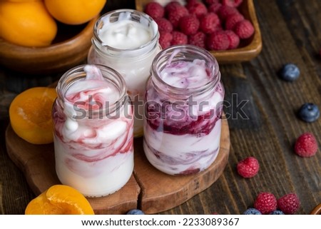 Fresh delicious yogurt made from milk with berry flavor, yogurt with fresh berries and jam