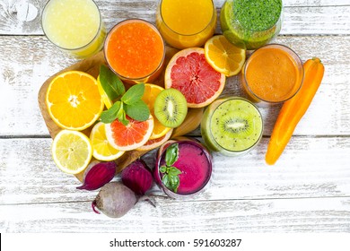 Fresh detox juices from fruit and vegetables in glass bottles on a wooden background