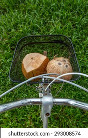 Fresh And Dried Brown Coconuts In A Bicycle Basket With Green Grass At Background, Top View