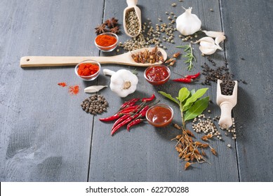 fresh and dried chili fruits, peppercorn, pepper powder, sauce and garlic, bay leaves on old black wooden table background - Shutterstock ID 622700288