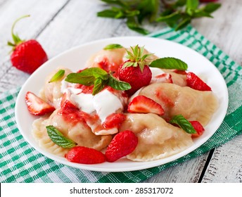 Fresh dumplings with strawberries and sour cream