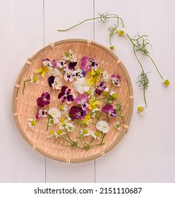 Fresh Edible Flowers On A Plate. Viola And Chamomile Flowers In The Garden.