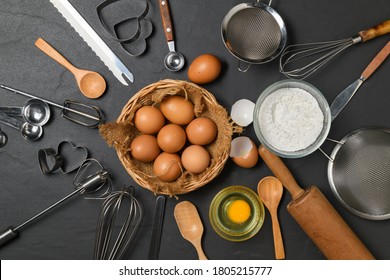 Fresh Eggs In Basket And Kitchen Utensils For Pastries On Black Table And Copy Space, Prepare For Make Cake And Bakery Concept