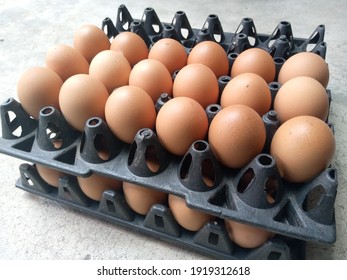 Fresh Eggs On Black Plastic Egg Tray.