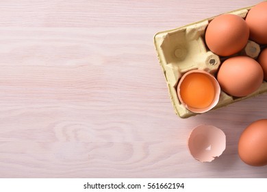 Fresh Eggs On Yellow Cardboard Egg Cups On Wooden Bench. Top View. Horizontal Composition