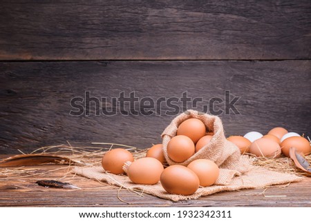 Fresh eggs are placed on a wooden table and fresh eggs are placed in an organic farm sack bag.