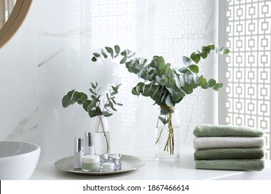 Fresh Eucalyptus Branches And Cosmetic Products On Countertop In Bathroom