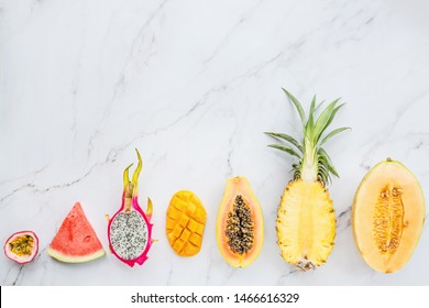 Fresh Exotic Fruits And Tropical Palm Leaves On White Marble Background - Papaya, Mango, Pineapple, Passion Fruit, Dragon Fruit, Melon. Mockup, Flat Lay, Overhead. Top View.