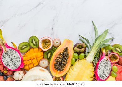 Fresh Exotic Fruits And Tropical Palm Leaves On White Marble Background - Papaya, Mango, Pineapple, Passion Fruit, Dragon Fruit, Melon. Mockup, Flat Lay, Overhead. Top View.