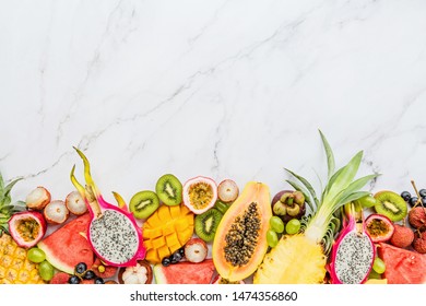 Fresh Exotic Fruits And Tropical Palm Leaves On White Marble Background - Papaya, Mango, Pineapple, Passion Fruit, Dragon Fruit, Melon. Mockup, Flat Lay, Overhead. Top View.