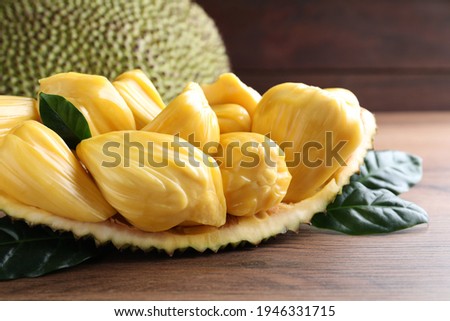 Fresh exotic jackfruit bulbs on wooden table, closeup