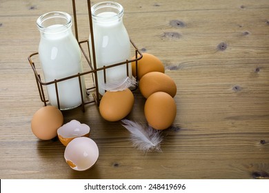 Fresh farm eggs and milk on wood table.