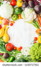 Fresh Farm Produce, Colorful Frame Made Of Organic Vegetables And Herbs On White Wooden Background, Healthy Background, Copy Space For Text In The Middle, Top View, Selective Focus