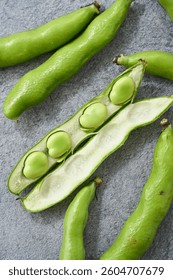 Fresh Fava Beans in Pods on a Gray Background – Spring Ingredient
