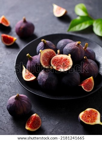 Fresh figs on black plate. Dark background. Close up.
