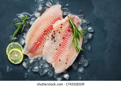 Fresh Fish Fillet Of Sea Bass In Ice On A Dark Slate Background. Top View.