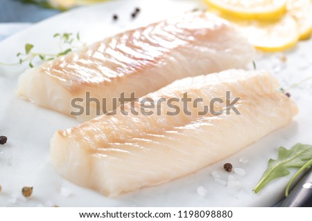 Fresh fish, raw cod fillets with addition of herbs and lemon 