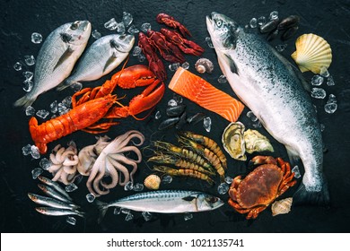 Fresh fish and seafood arrangement on black stone background - Powered by Shutterstock