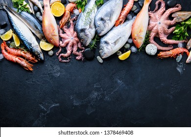 Fresh Fish And Seafood Assortment On Black Slate Background. Top View. Copy Space.