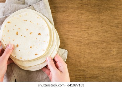 Fresh flour tortillas on a wood background.