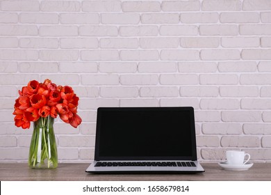 Fresh Flower Composition, Bouquet Of Darwin Hybrid Tulips With Black And White Laptop Computer, White Brick Wall Background. Office Romance Concept. Copy Space, Close Up, Top View, Flat Lay.