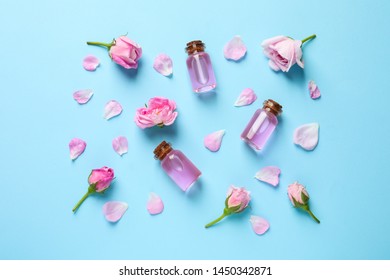 Fresh flowers, petals and bottles of rose essential oil on color background, flat lay - Shutterstock ID 1450342871