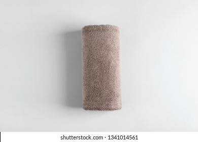 Fresh fluffy rolled towel on grey background, top view