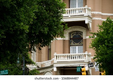 Fresh Foliage Frames A Balcony Of A Victorian Building On Sixth Street In Austin, Texas